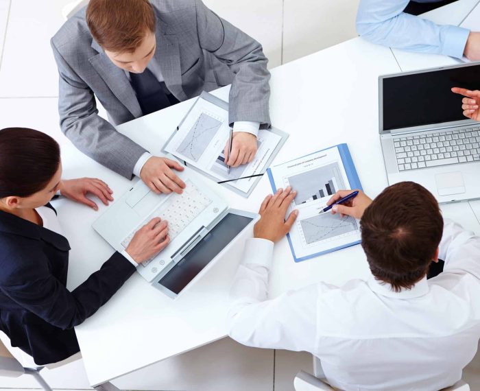 Above view of business team sitting around table and working